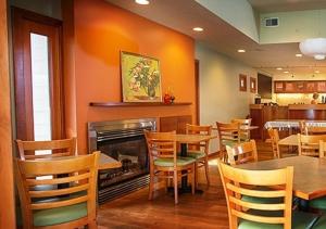 a restaurant with tables and chairs and a fireplace at Summers Inn Ludington - Adults Only in Ludington