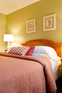a bedroom with a bed with a red blanket and a lamp at Summers Inn Ludington - Adults Only in Ludington