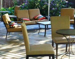 a patio with chairs and tables and a table with a couch at Summers Inn Ludington - Adults Only in Ludington