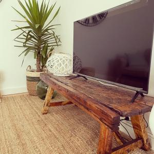 a living room with a tv and a wooden bench at El desván de Bruno in Villalobos