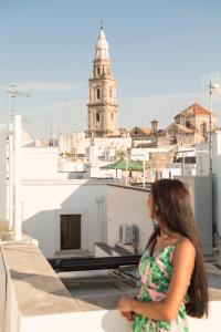 una mujer parada en un techo mirando a una ciudad en Dimora Pietrabianca, en Monopoli