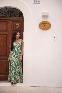 Una donna con un vestito in piedi davanti a una porta di La Perla Del Mare a Monopoli