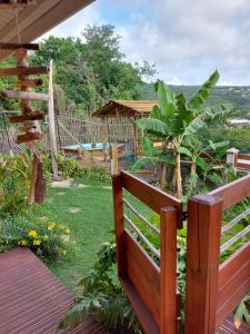 un banco de madera sentado en una terraza en un jardín en Kreyol Lodges - Suite Kayou en Deshaies