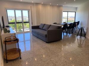 a living room with a couch and a table with chairs at Beach Front with Rooftop in Vila do Conde