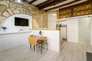 ein Esszimmer mit einem Tisch und einem TV an der Wand in der Unterkunft apartamento loft a 50 metros de la playa y paseo maritimo in El Campello