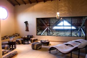 a room with beds and tables and a large window at San Ceferino Hotel & Spa in Open Door