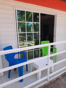 een veranda met kleurrijke stoelen en een raam bij Mayo´s Place in San Andrés