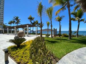 a park with palm trees and the ocean at Camino al mar 2303 vista al mar in Mazatlán
