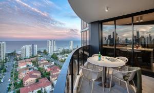 a balcony with two tables and a view of the city at Encore Broadbeach in Gold Coast