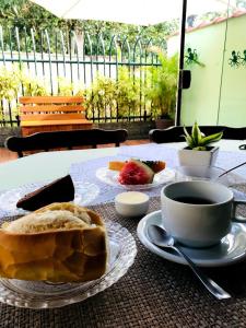 a table with a plate of bread and a cup of coffee at Porto Abraão Pousada in Abraão