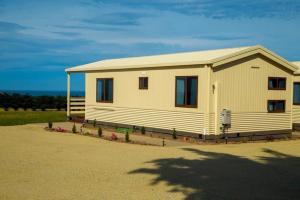 a small white house with a roof at OMARU FARM STAY in Ventnor