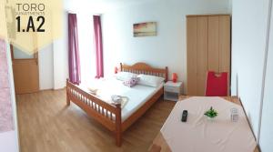 a bedroom with a bed and a table in it at Apartments Toro in Pag