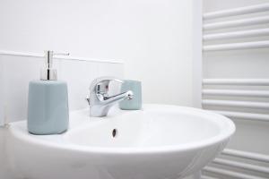 a bathroom sink with a soap dispenser on it at St Thomas Loft Views by Stay South Wales in Swansea