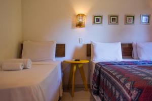 1 dormitorio con 2 camas y una mesa pequeña en Pousada Parque da Mata, en Paraty