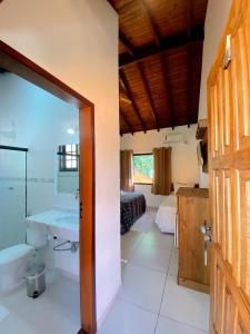 a bathroom with a tub and a sink in a room at Pousada Parque da Mata in Paraty