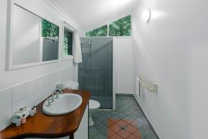 a bathroom with a sink and a shower at Ferntree Rainforest Lodge in Cape Tribulation