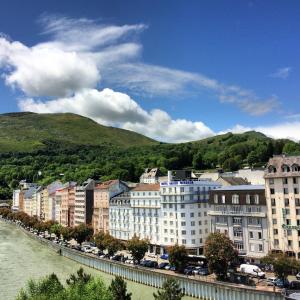 une ville à côté d'une rivière avec des bâtiments dans l'établissement Appart'hôtel Saint Jean, à Lourdes