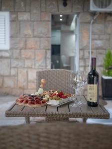 a table with a plate of food and a bottle of wine at Luxury Boutique Studio in Budva