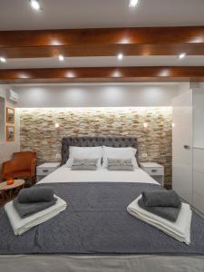 a bedroom with a large bed and a brick wall at Luxury Boutique Studio in Budva