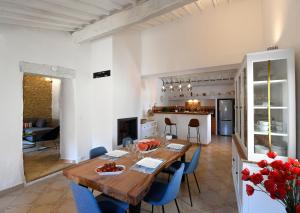 魯西永的住宿－Gîte des Demoiselles en Luberon，厨房以及带木桌和蓝色椅子的用餐室。