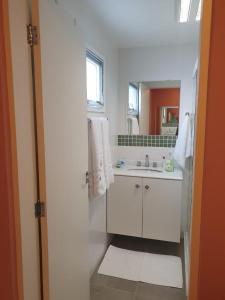 um banheiro branco com uma pia e um espelho em Pouso Mantiqueira em Cunha