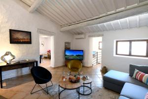 a living room with a couch and a tv at Gîte des Demoiselles en Luberon in Roussillon