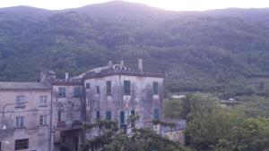 ein altes Gebäude mit einem Berg im Hintergrund in der Unterkunft I Tre Ponti in Borgonovo