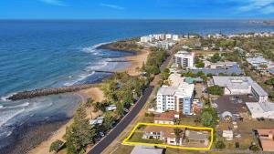 an aerial view of a beach with buildings and the ocean at Nautilus Beachside Apartments in Bargara