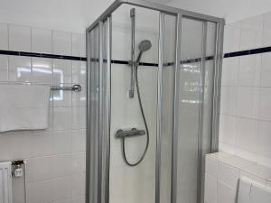W łazience znajduje się prysznic ze szklanymi drzwiami. w obiekcie Residenz Hotel Neu Wulmstorf w mieście Neu Wulmstorf