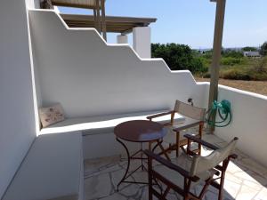 a small balcony with two chairs and a table at To Pithari in Skiros