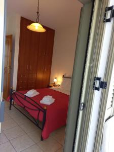 a room with a bed with a red blanket at To Pithari in Skiros