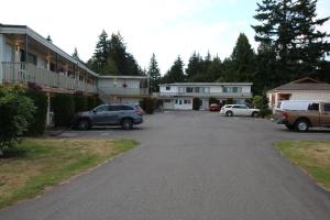 a parking lot with cars parked in front of houses at Skylite Motel in Parksville