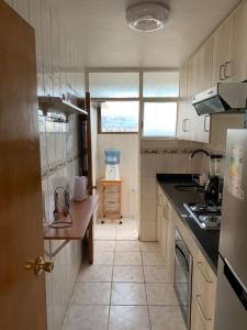 uma cozinha com um lavatório e uma bancada em Departamento Amoblado Talca em Antofagasta