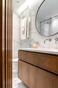 a bathroom with a sink and a mirror at Glyfada Gallery Apartment in Athens