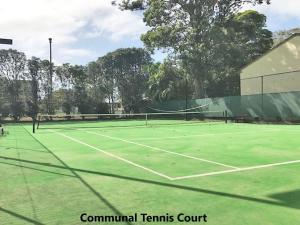 a tennis court with a tennis net on it at Bay Parklands 4, 2 Gowrie Avenue - pool & tennis court in Nelson Bay