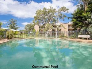 a swimming pool in front of a fence at Bay Parklands 4, 2 Gowrie Avenue - pool & tennis court in Nelson Bay