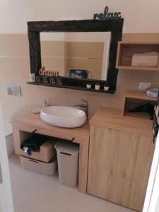 uma casa de banho com um lavatório e um espelho em Apartmani Kiko em Porec