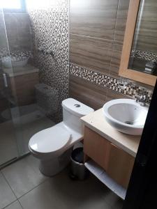 a bathroom with a toilet and a sink and a shower at Moderno departamento 3B en Condominio La Victoria in Cuenca