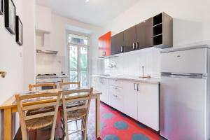 a kitchen with white cabinets and a table and a refrigerator at La casa di Andrea ai Musei Vaticani 1 in Rome +20 photos