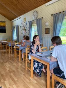 una mujer sentada en una mesa comiendo comida en Kastelholms Gästhem en Sund