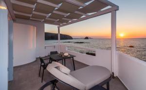 Un balcón con una mesa y una silla y el océano en Tania Milos, en Pollonia