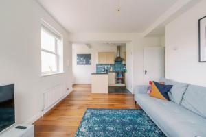a living room with a couch and a kitchen at Pass the Keys Bright Apartment in Peckham with Free Parking in London
