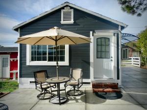a table with chairs and an umbrella in front of a house at Your Most Romantic and Peaceful Getaway in El Sobrante