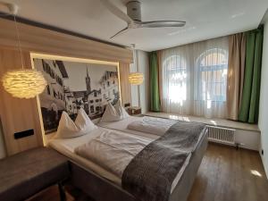 a bedroom with a large bed and a large window at Hotel Adler in Golling an der Salzach