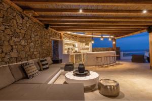 a living room with a couch and a stone wall at Villa Maera Maximus in Mikonos