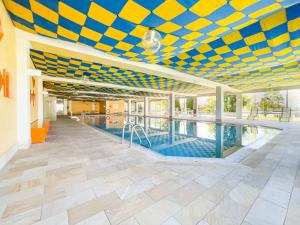 a swimming pool with a blue and yellow ceiling at FeWo Längl -Alpenguck- mit Pool und Sauna im Allgäu in Scheidegg