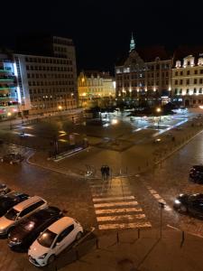 a city at night with cars parked in a parking lot at Elegant 2BR, Amazing Old Town Views, Plac Solny Walk to Rynek! Amenities in Wrocław