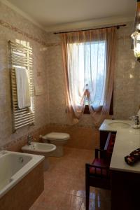 ein Badezimmer mit einer Badewanne, einem WC und einem Waschbecken in der Unterkunft Agriturismo Nonno Mario in Fossone dʼAdige