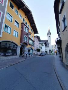 a city street with a yellow building and a church at Hotel Adler in Golling an der Salzach