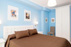 a blue bedroom with a bed and a chair at CasAlice B&B Napoli in Naples